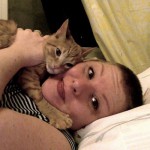 Audra Williams snuggling an orange kitten.